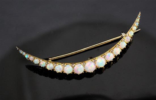 An early 20th century gold and silver, graduated white opal crescent brooch, 2in.